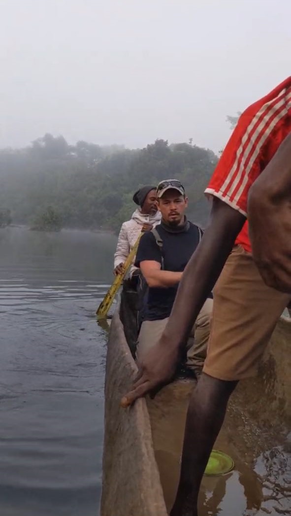 Line of men with backpacks walking into a remote village.